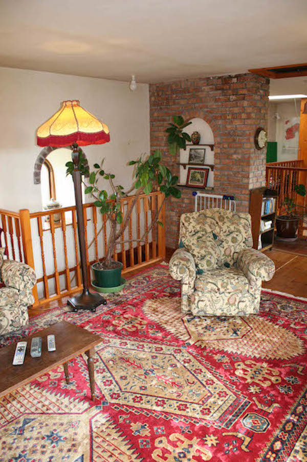 Stairs down to bedrooms behind lamp and bannisters